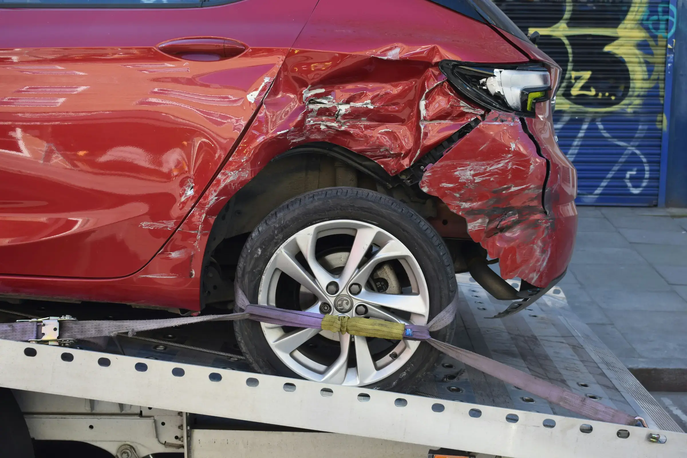 Wrecked car secured to the back of a tow truck