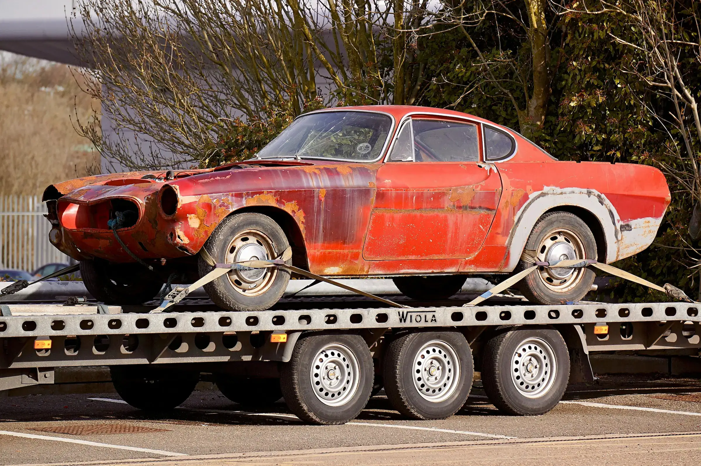 Junk car being removed via tow truck