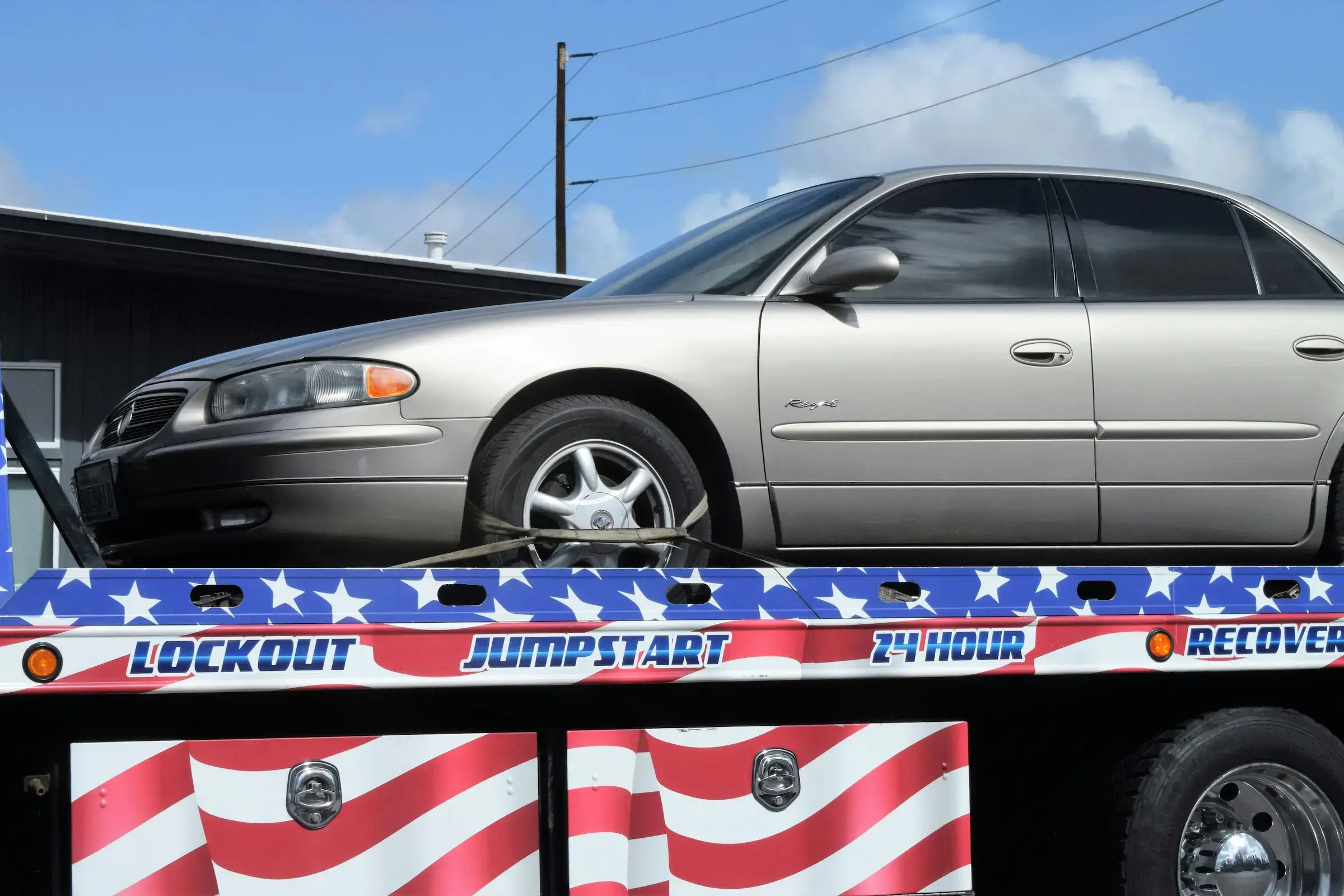 Sedan secured onto tow truck flatbed